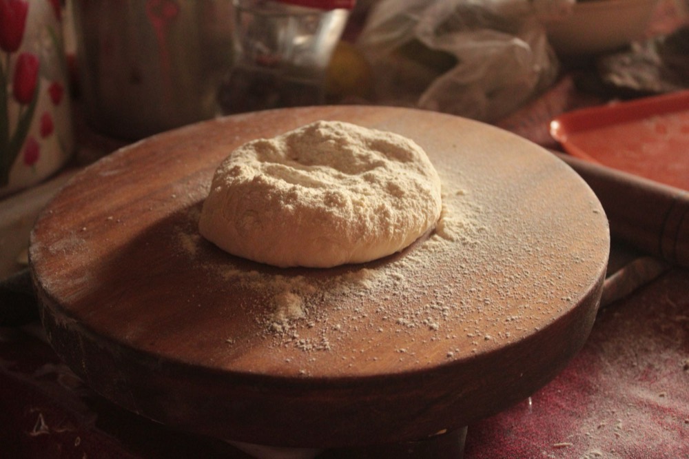 A round of dough resting on a floured board